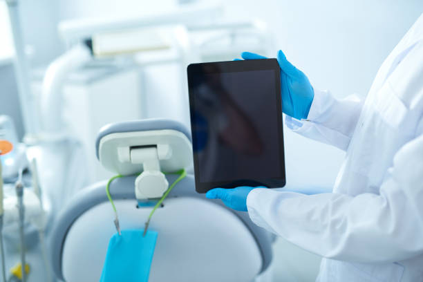 istock Dental surgeon presenting tablet to the camera 1183945353