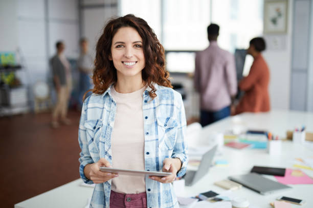 istock Cheerful Young Woman Posing in Creative Agency 1183945632