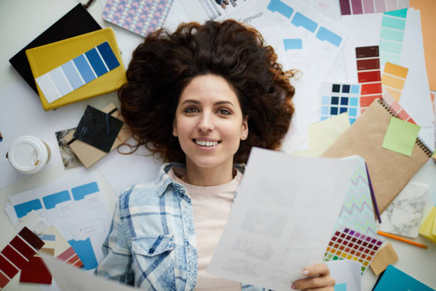 istock Smiling Young Woman in Creative Mess 1183945688