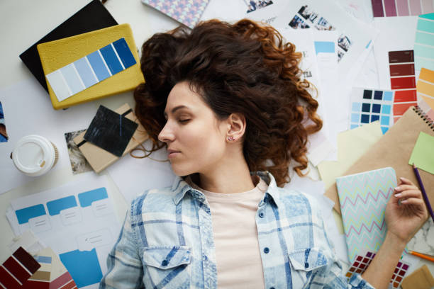 istock Beautiful Young Woman Lying in Creative Mess 1183945693