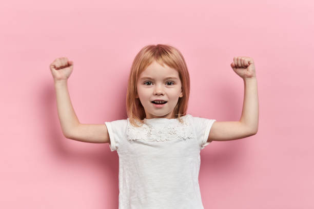 istock little cute strong girl showing her biceps 1183946071