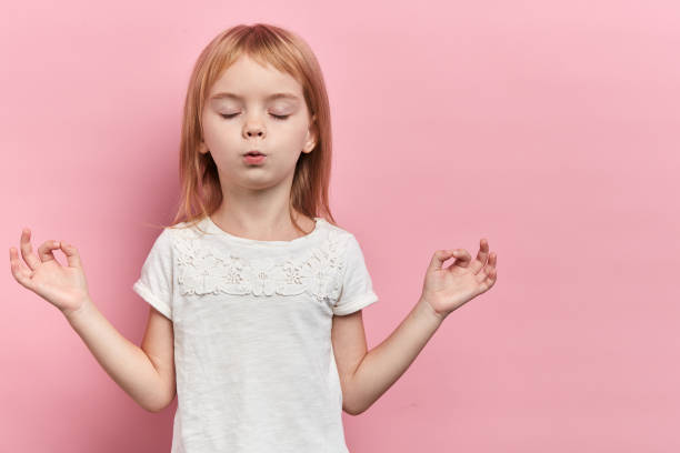 petite fille mignonne détendue pratiquant le yoga, d'isolement sur le rose - resting place photos et images de collection