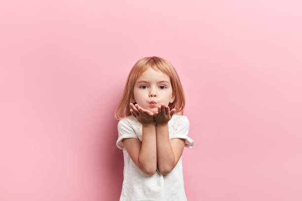 cute lovely girl sending kiss cute lovely girl sending kiss, close up portrait, isolated pink background, studio shot. blowing a kiss stock pictures, royalty-free photos & images