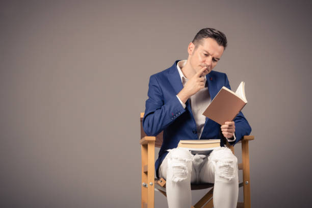 istock Thoughtful man reading a book against the wall. 1183947042