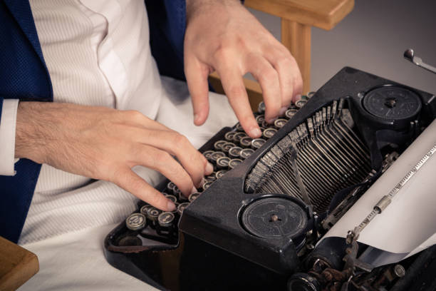 istock Close-up of man typing on old typewriter. 1183947046