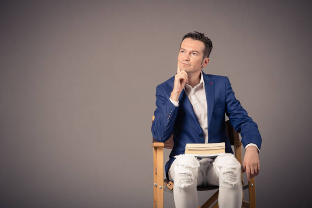 istock Man with books contemplating against the wall. 1183947075
