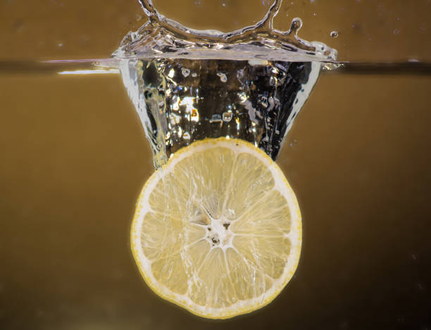 istock lemon slices are thrown into the water on a yellow background and splash 1183947149
