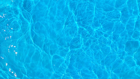 agua ondulada azul en la piscina. superficie de agua en fondo de textura azul. vista superior y copiar espacio para las vacaciones de verano. photo