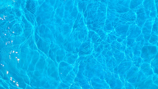 The surface of the sea, which has a shimmering blue-green color. The water looks calm and tranquil, with small waves creating ripples on the surface.