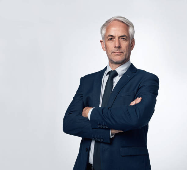 You can't afford to mess around in business Portrait of a mature businessman standing with his arms crossed against a grey background ceo photos stock pictures, royalty-free photos & images
