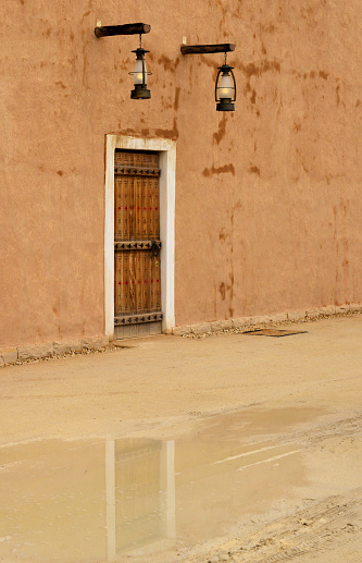 Puerta en la pared vieja, decoración najdi - reflejo de charco en un día lluvioso - Ad Diriyah, Distrito de At-Turaif, Patrimonio de la Humanidad de la UNESCO, Riad, Arabia Saudita photo
