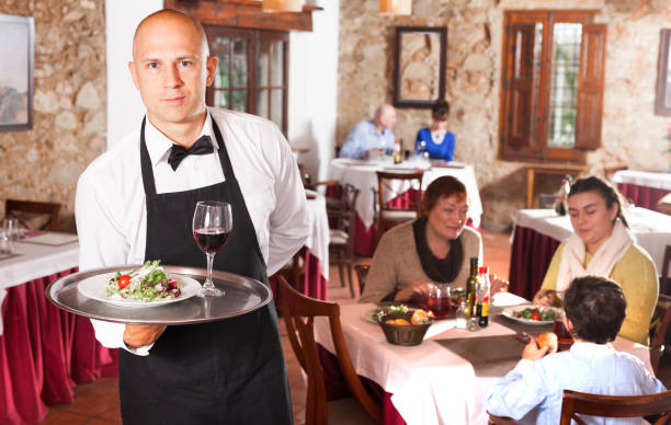 istock Waiter in white shirt holding tray 1183954030