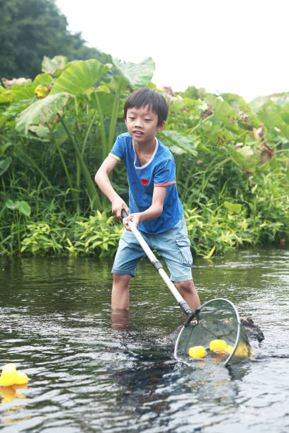 istock Child playing by a stream fishing 1183955058