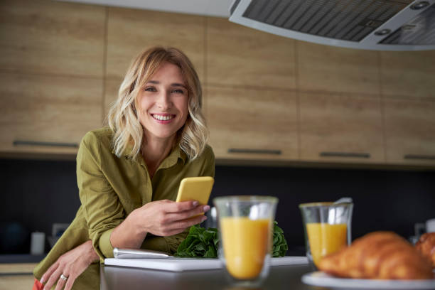 istock Smiling pretty lady is holding mobile phone 1183957337