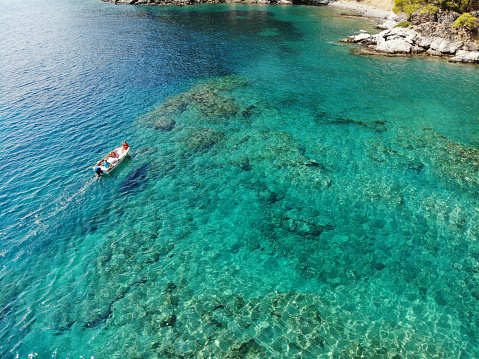 typical coast line with dark blue sea and jagged rocks with few green plants in Menorca