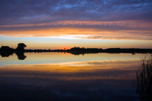 istock Colorful clouds in the sky after sunset, reflection in the water 1183958280