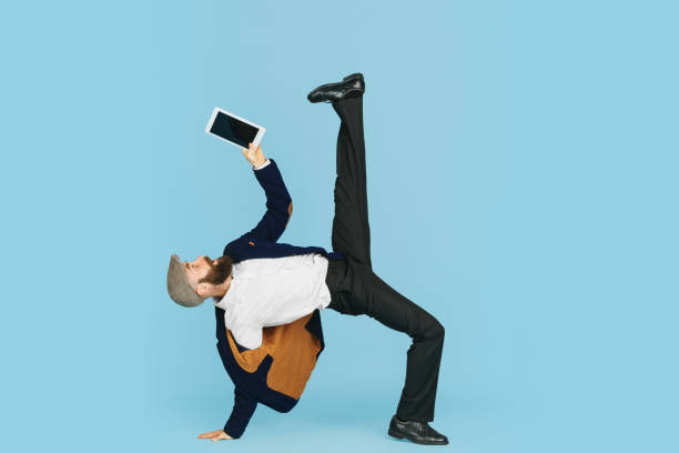 istock Businessman having fun dancing break dance on blue background at work 1183958767