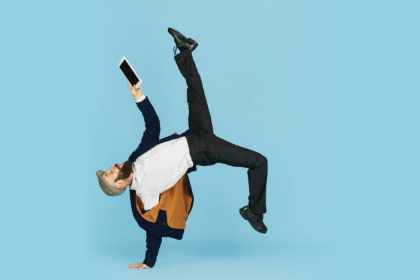 istock Businessman having fun dancing break dance on blue background at work 1183958771
