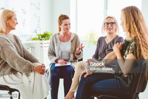 Professional Discussing With Group In Therapy Stock Photo - Download Image Now - 35-39 Years, 40-44 Years, Adult