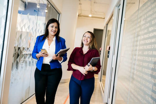 istock Lighthearted Hispanic businesswomen walking in office 1183961218
