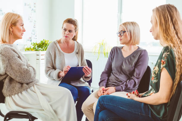 istock Woman discussing experiences with group in session 1183961249