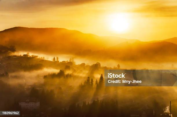 Fantastic Sunrise In A Mountain Village With Sunrays Passing Through A Foggy Hills Stock Photo - Download Image Now