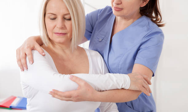 istock Physiotherapist working with middle aged patient in clinic 1183963072