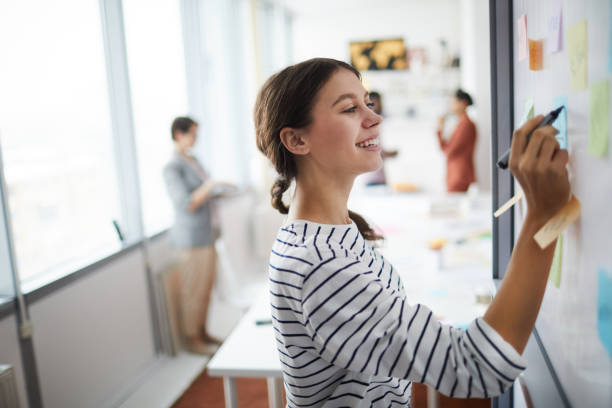 istock Young Woman Writing on Board 1183963460