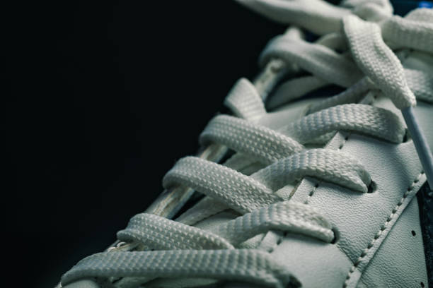 istock Beautiful white shoeloces  on a dark background texture. 1183963601