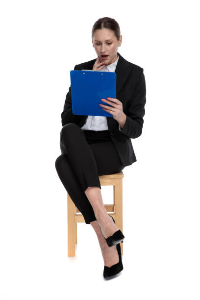 istock businesswoman looking down at clipboard shocked 1183966751