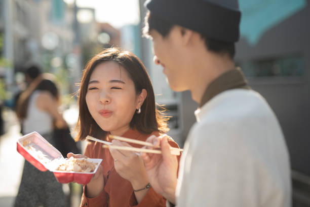 молодая пара есть еду на улице - couple loving urban scene selective focus стоковые фото и изображения