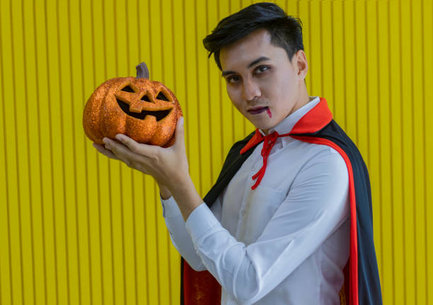 Man holding orange pumpkins on Halloween night