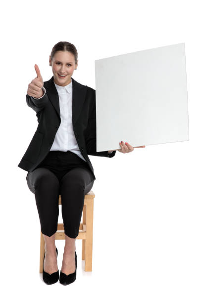 istock busiensswoman sitting and holding billboard while making ok sign 1183968485