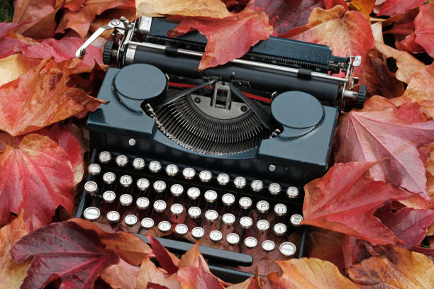 istock Vintage type-writer partly covered with fallen leaves 1183973647