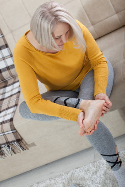 Middle-aged woman suffering from pain in leg at home, closeup. Physical injury concept. Middle-aged woman suffering from pain in leg at home, closeup. Physical injury concept. Ankle pain, painful point. painfully stock pictures, royalty-free photos & images