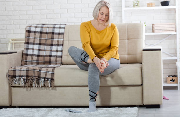 Middle-aged woman suffering from pain in leg at home, closeup. Physical injury concept. Middle-aged woman suffering from pain in leg at home, closeup. Physical injury concept. Ankle pain, painful point. painfully stock pictures, royalty-free photos & images