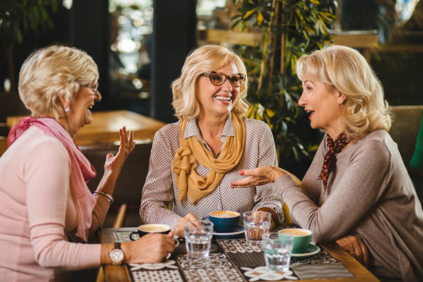 istock Three senior ladies socializing over coffee in cafe 1183977703