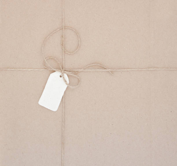 istock Cardboard packaging packed with jute and paper label from the dough. Paper texture. Abstract background. 1183978232