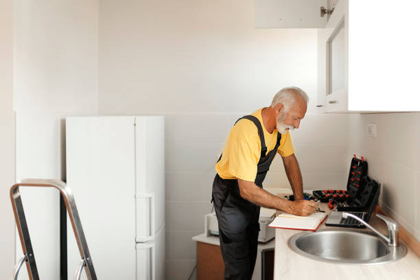 istock Senior Handyman Fixing Kitchen Cabinet 1183978344