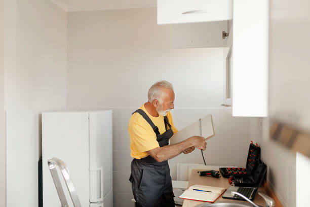 istock Senior Handyman Fixing Kitchen Cabinet 1183978349