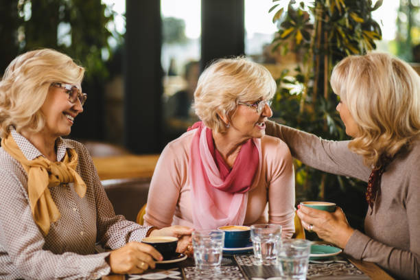 istock Three senior ladies socializing over coffee in cafe 1183979125