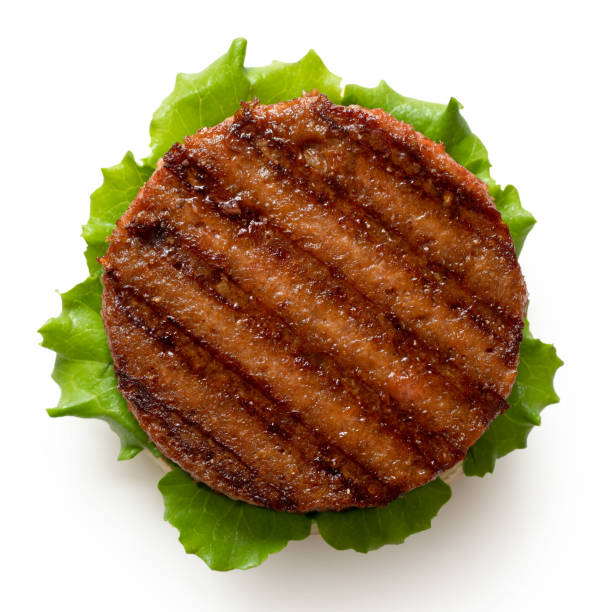 Freshly grilled plant based burger patty on bun with lettuce isolated on white. Top view. Freshly grilled plant based burger patty on bun with lettuce isolated on white. Top view. veggie burger stock pictures, royalty-free photos & images