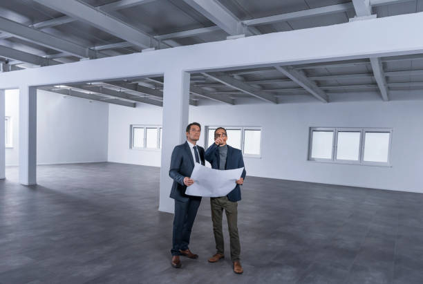 istock Businessmen discussing blueprint 1183980480