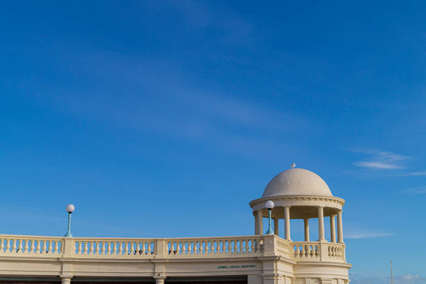 A view of one of the cupolas on the De La Warr Pavilion in Bexhill, East Sussex. The photo is taken from promenade level and shows the architecture against a blue sky.