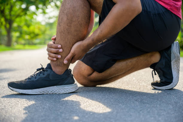 istock Broken twisted ankle. Runner touching foot in pain due to sprained ankle 1183984476