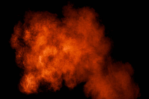 istock Orange red  powder explosion on black background.Orange red color dust splash clouds. 1183984756