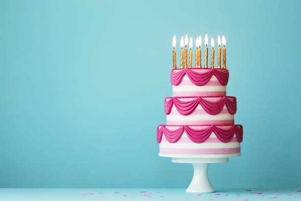 istock Tiered birthday cake with golden candles 1183985907
