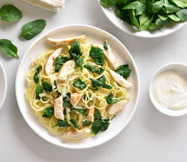 istock Spaghetti with spinach leaves, slices grilled chicken breast and grated cheese 1183989608