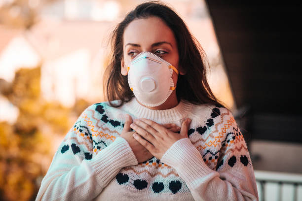 femme avec le masque respiratoire dehors dans la ville polluée - smog city pollution town photos et images de collection