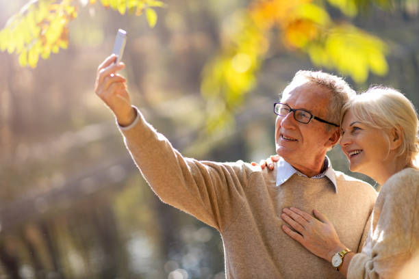 istock Senior couple taking selfie with smartphone in park 1183991151